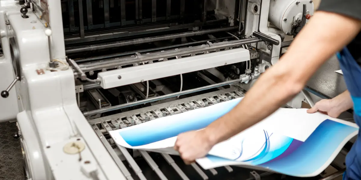 Image of paper being printed on a production printing press