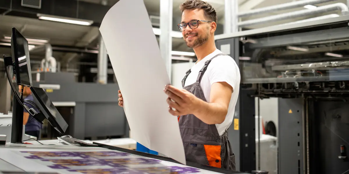Professional production printing worker looking at printed poster
