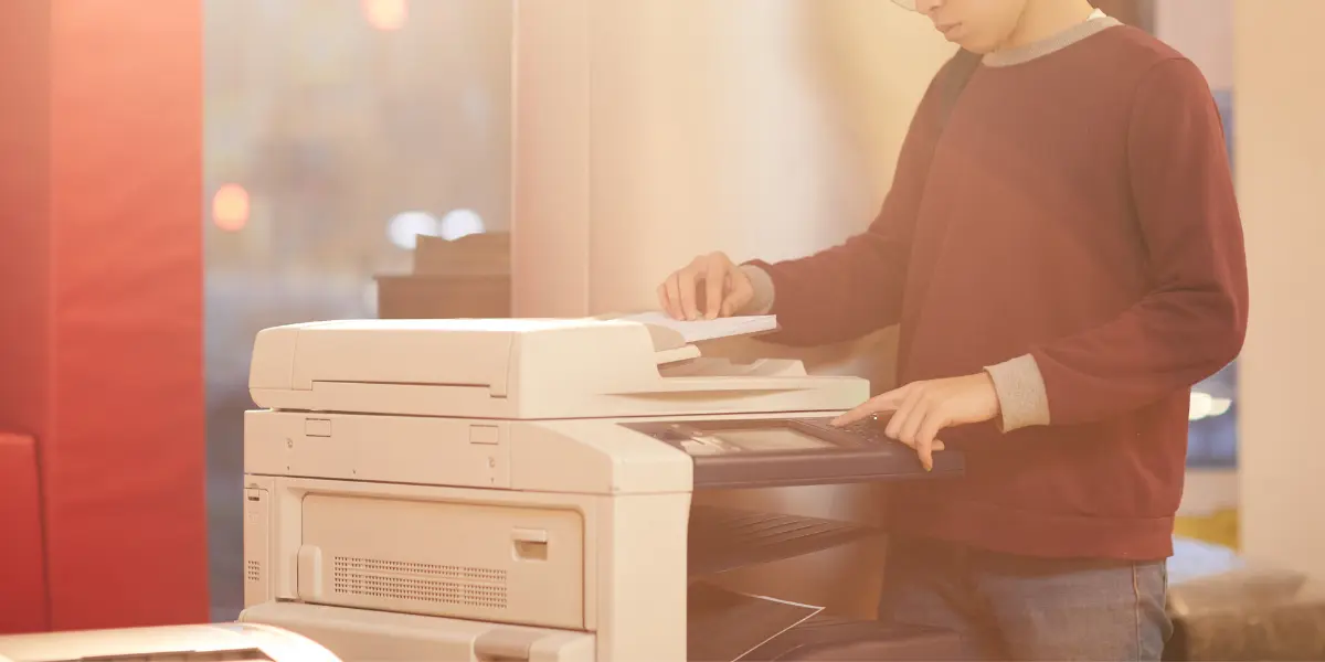Person standing next to copy machine that needs emergency repair